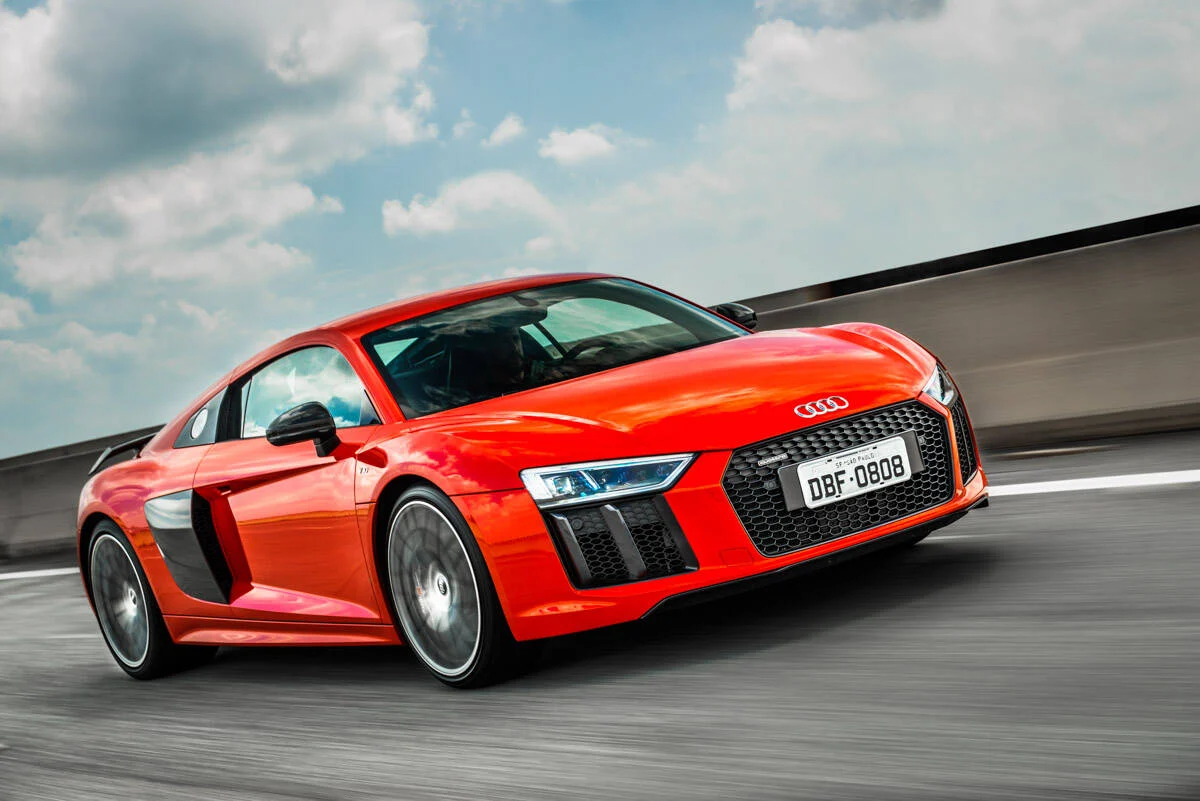 10. Audi R8 V10 Plus - R$ 1.234.990 O Audi R8 V10 Plus é o superesportivo mais potente da marca, com um motor 5.2 V10 de 610 cv e um câmbio S tronic de sete velocidades e dupla embreagem. O carro acelera de 0 a 100 km/h em 3,2 segundos e atinge uma velocidade máxima de 330 km/h. O design é aerodinâmico e agressivo, com faróis de LED, rodas de 20 polegadas e spoiler traseiro fixo.
